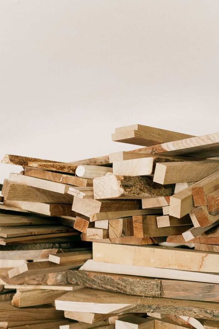 testimonial-img-02 A detailed view of stacked wooden planks ready for crafting and woodworking projects.