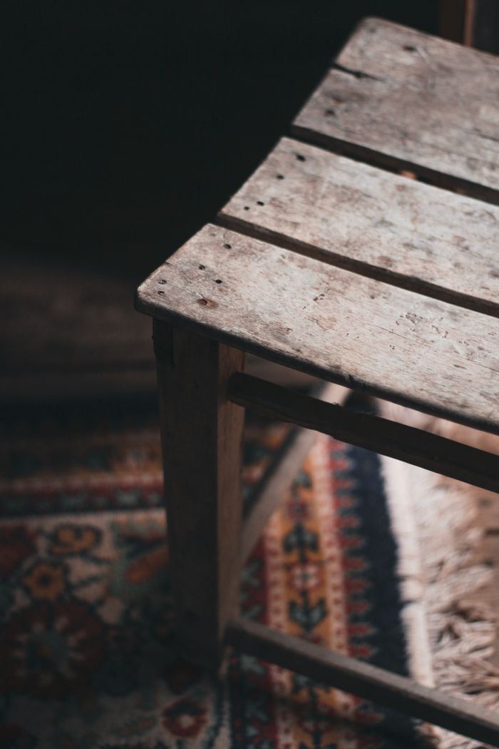 testimonial-img-01 From above of shabby wooden chair placed on blurred ornamental rug in sunlight